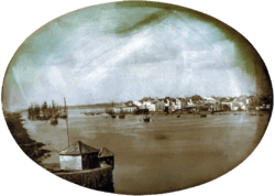 An elevated view across the Capibaribe River to Recife's harbor with the city in the background