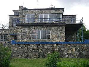 photograph of a stone-built house in 'International' style, with blue woodwork