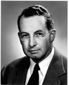 Head and shoulders of a man in suit and tie with glasses