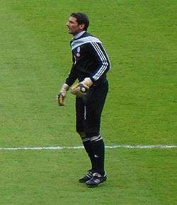 A man wearing a black football kit before a game.