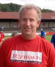 A man with grey hair is wearing a red top.