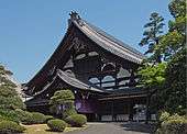 Blue skies, pointed roof on a building in front