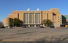 Photograph of the auditorium that is mostly rectangular except for a lower cylindrical portion on the left lower edge covering the ramps and a portion projecting above the roofline to the right