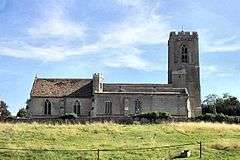 A long stone church with a west tower and a rood tower at the junction of the nave and chancel