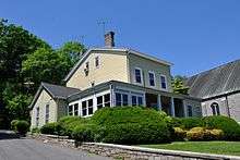 A square two-story yellow house