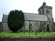 A small stone church from the north with a west tower and higher stair turret