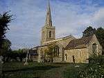 A stone church seen from the southeast, showing chancel, beyond which is a taller nave with a south aisle, and a tower with a spire