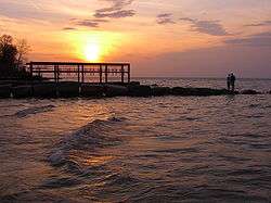 Two people watch a sunset at Veterans Memorial Park in Avon Lake, OH.