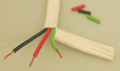 Broad white-coated cable, cut away to show green, red and black coated wires