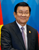 a smiling man with black hair, dressed in a suit with a purple tie