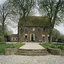 Red brick building behind two trees