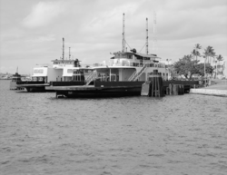 Two large ferries docked on an island on a clear day