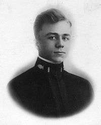 Head of a young man with carefully combed hair wearing a dark military tunic with an oak leaf emblem and bar on the upright collar.