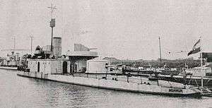 a black and white photograph of a ship tied up at a berth